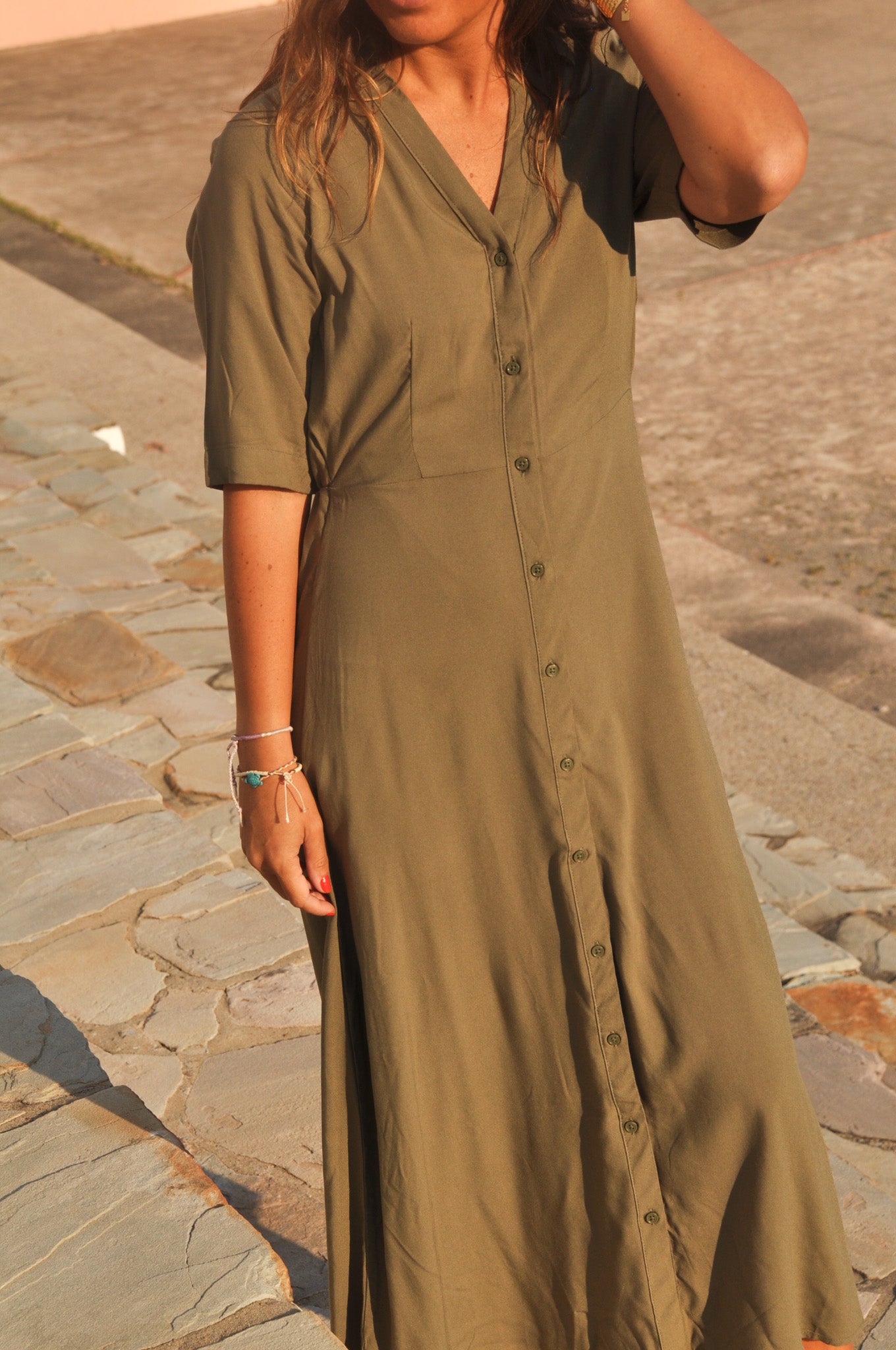 Zoom sur le buste d'une robe chemise kaki : col V et boutonnière frontale.