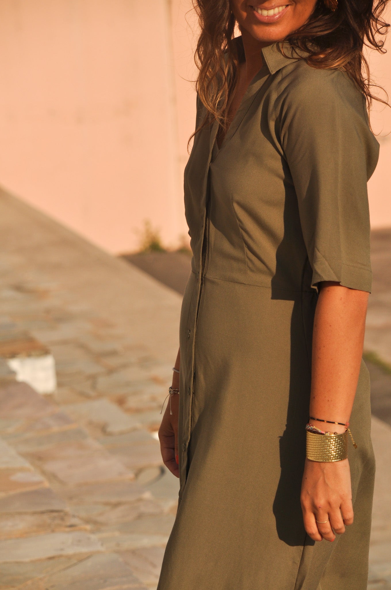 Vue de côté d'une robe longue kaki fluide : fente latérale discrète visible.