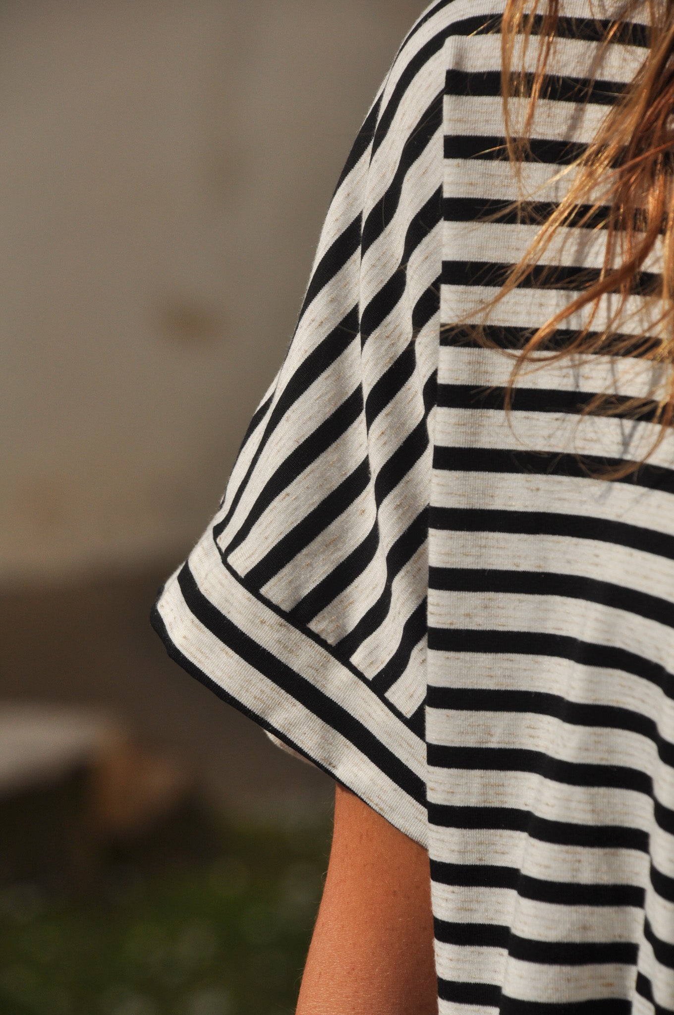 Focus sur la manche courte d'une marinière pour femme en coton rayé, montrant la maille fine