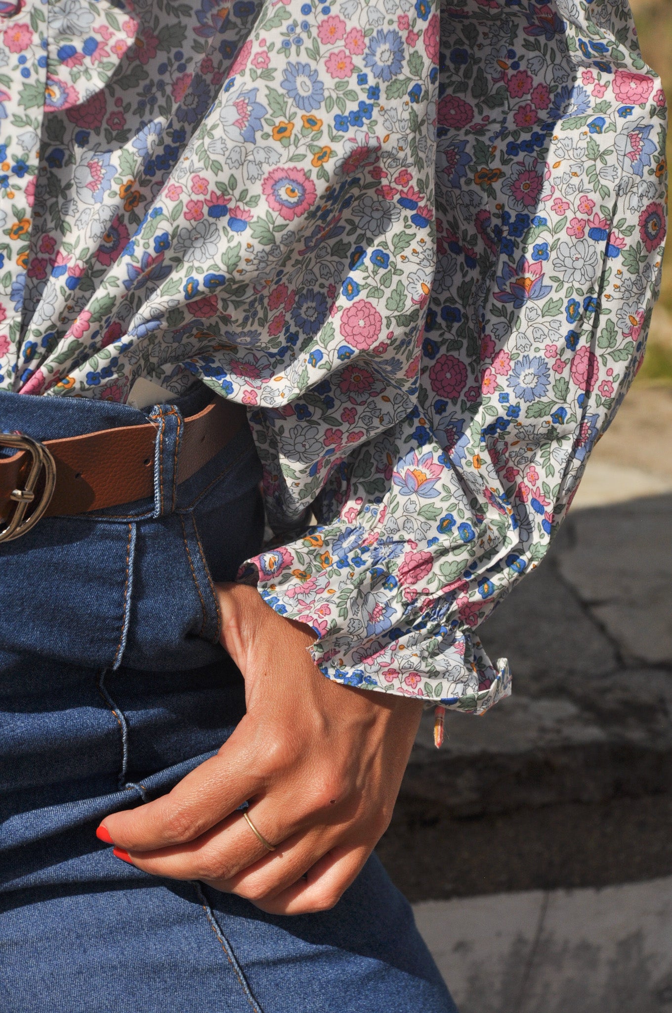 Détail des broderies fleuries ton sur ton sur le buste d'une blouse blanche en coton romantique.