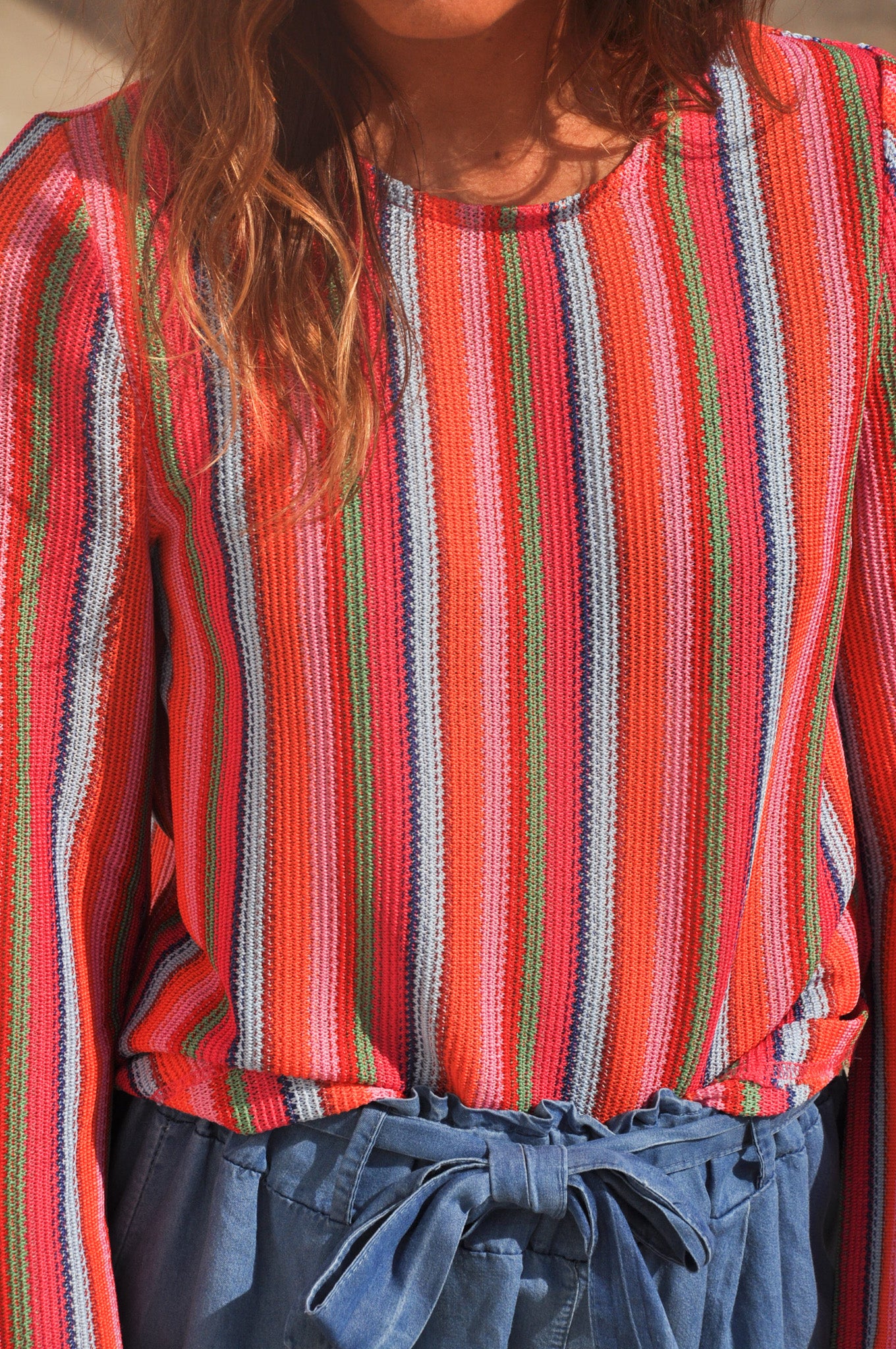 Détail du buste d'un pull pour femme à rayures verticales colorées en maille fine et col rond