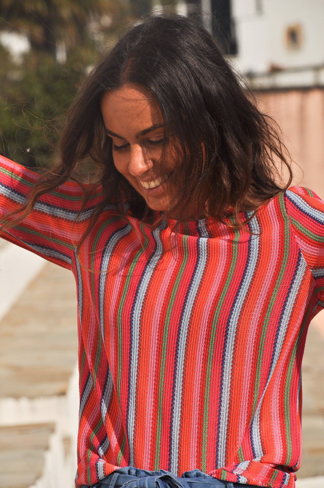 Portrait d'une femme portant le pull à rayures multicolores éclatantes, look bohème chic en extérieur