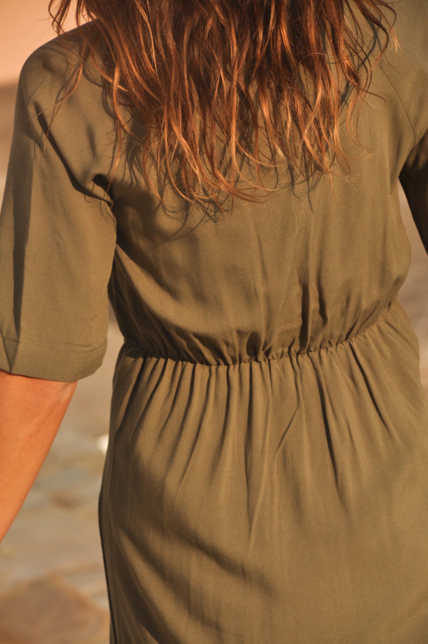 Gros plan sur la taille élastiquée (smocks) au dos d'une robe longue kaki