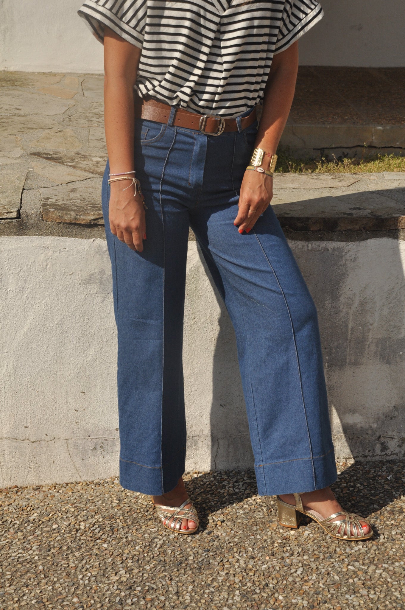 Aperçu des jambes d'un pantalon denim large femme à plis plats et surpiqûres contrastées.