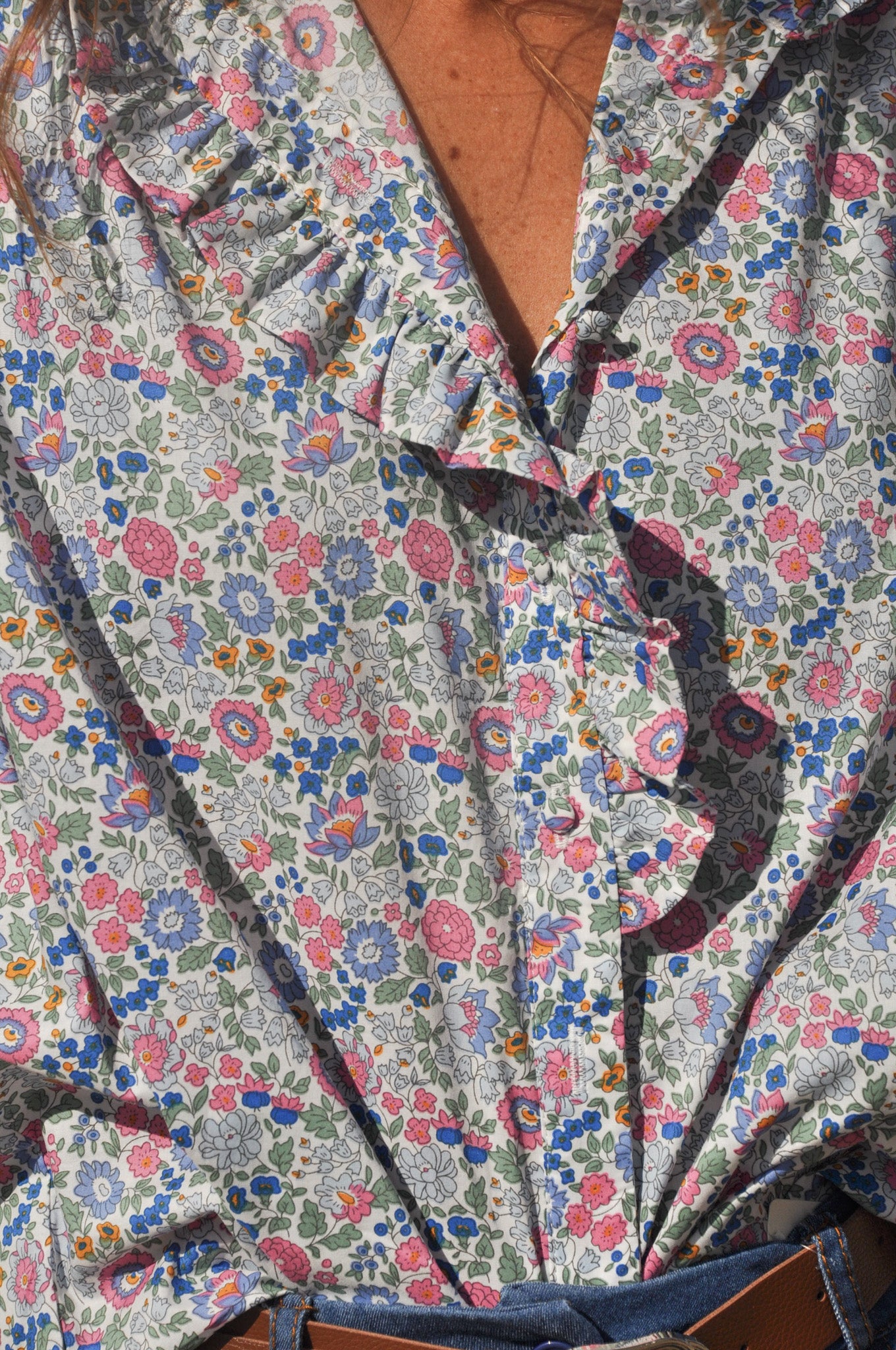 Gros plan sur le col v et les motifs brodés ajourés d'une blouse d'été blanche pour femme